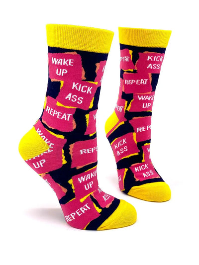 Women's crew socks with "Wake Up Kick Ass Repeat" text pattern, yellow accents, stylish and comfortable design.