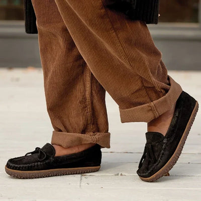 Minnetonka Tie-Tread Shoe in black suede, featuring signature stitch and rawhide lace.