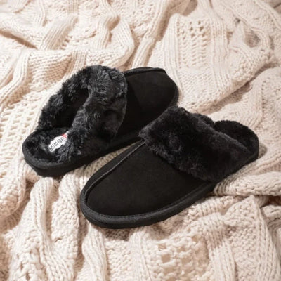 Minnetonka Chesney Cozy Suede Slippers on a knitted blanket.