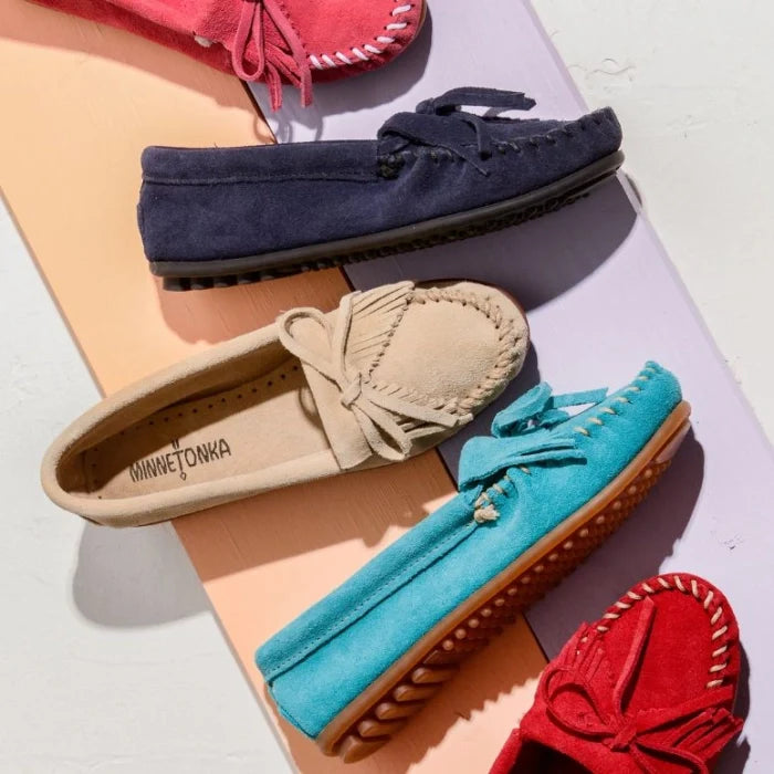 Minnetonka Kilty Hardsole Moccasins in various colors on display.