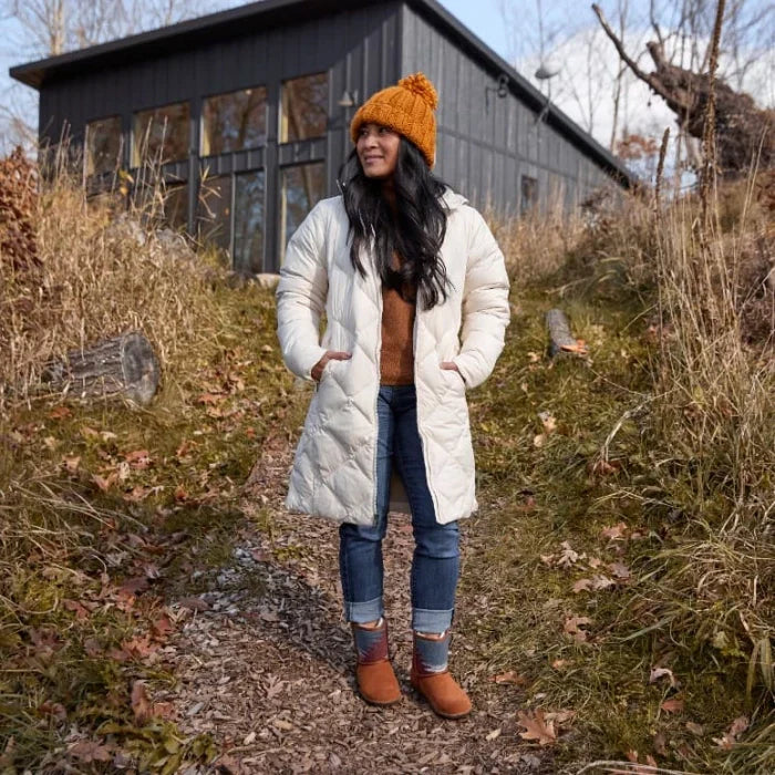 Woman wearing Minnetonka TALI shoes with a stylish insulated coat outdoors.