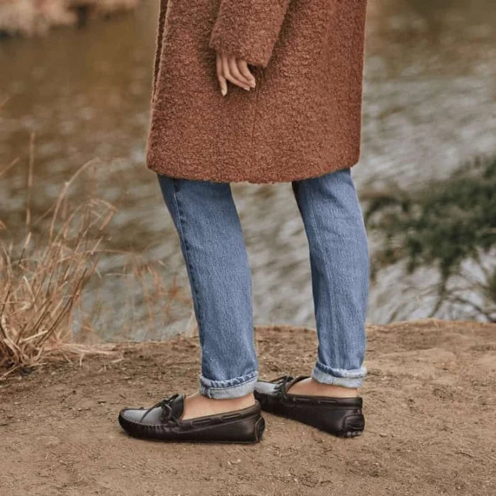Woman wearing Minnetonka CLASSIC DRIVER moccasins by a river.