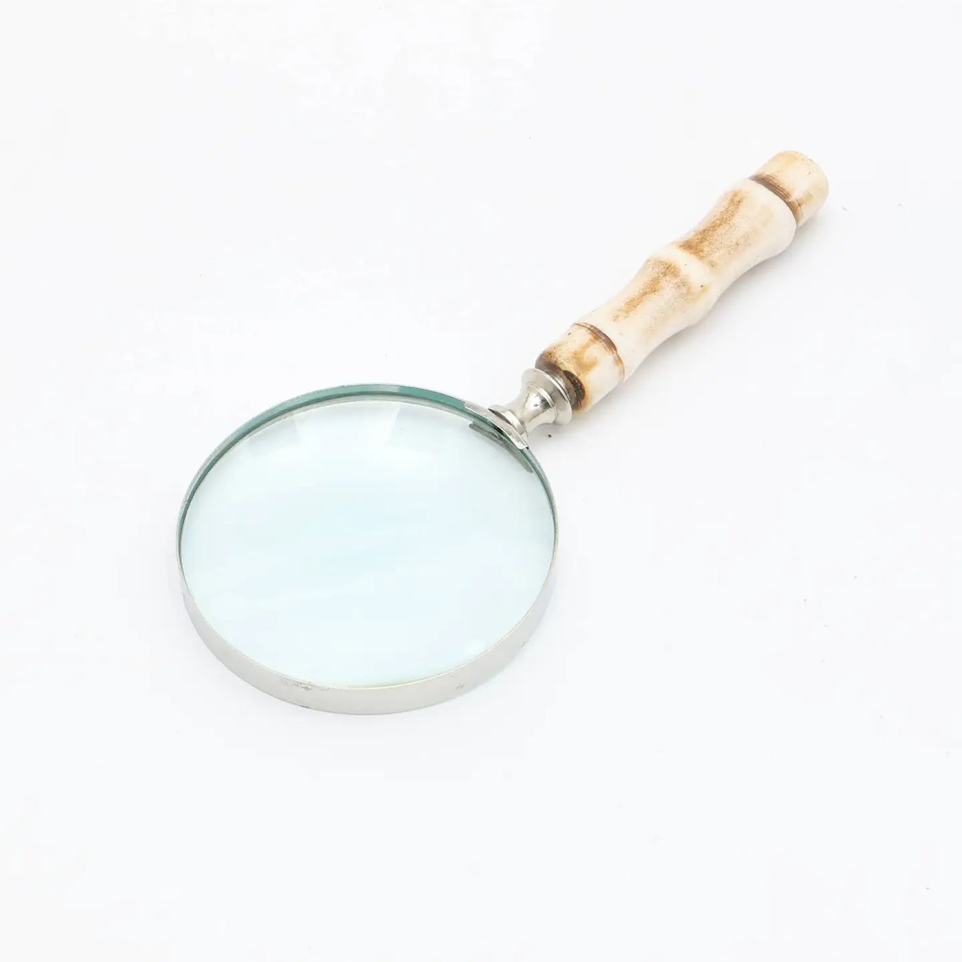 Decorative magnifying glass with silver electroplated frame and smooth resin handle on white background