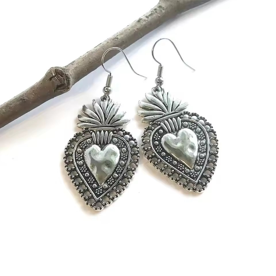 Silver Sacred Heart statement earrings with a bold, artistic design and large drop style.
