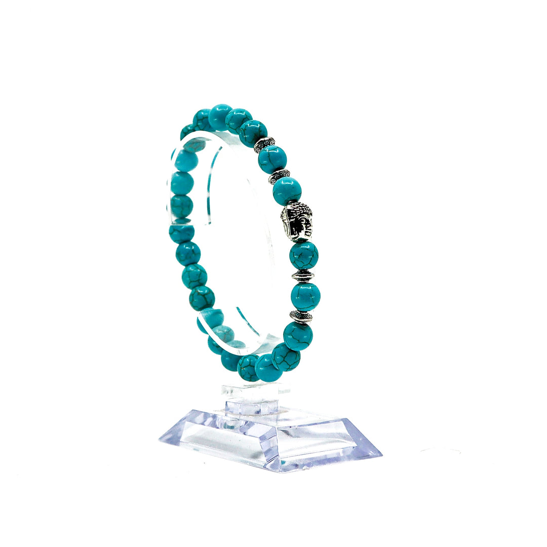 Turquoise bracelet set with natural stones and silver accents on clear display stand