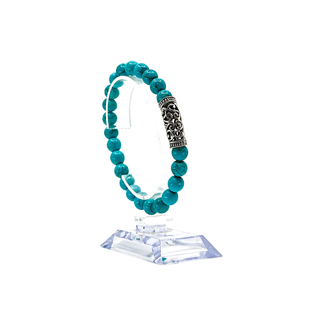 Turquoise Bracelet Set featuring vibrant turquoise beads and a decorative silver charm on a clear display stand