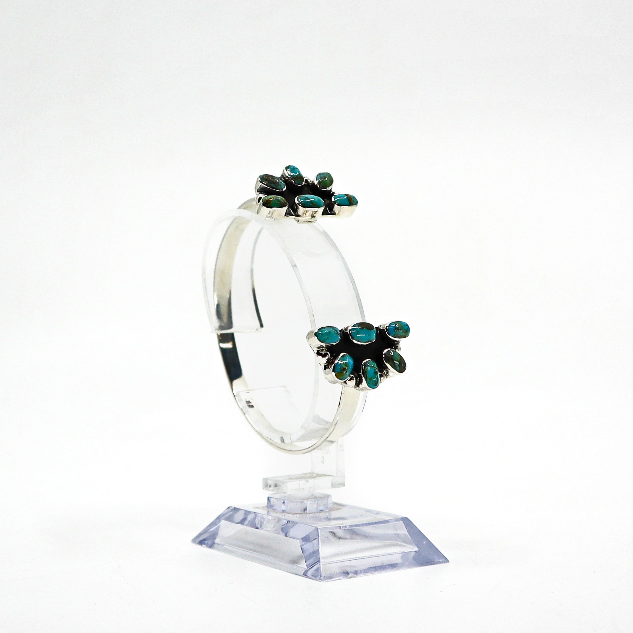 Handmade sterling silver cuff bracelet with turquoise stones on display stand