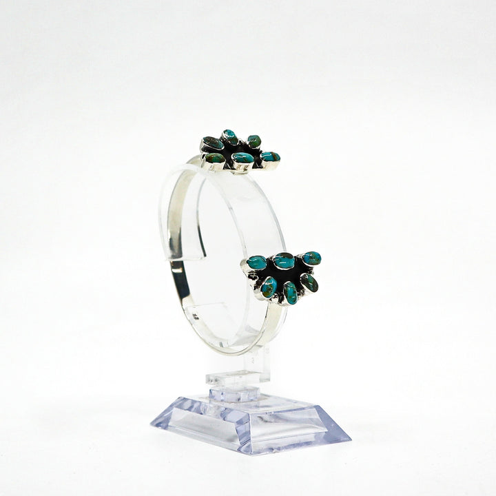 Handmade sterling silver cuff bracelet with turquoise stones on clear stand