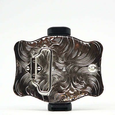 Intricately designed metal belt buckle with engraved floral patterns and a polished finish