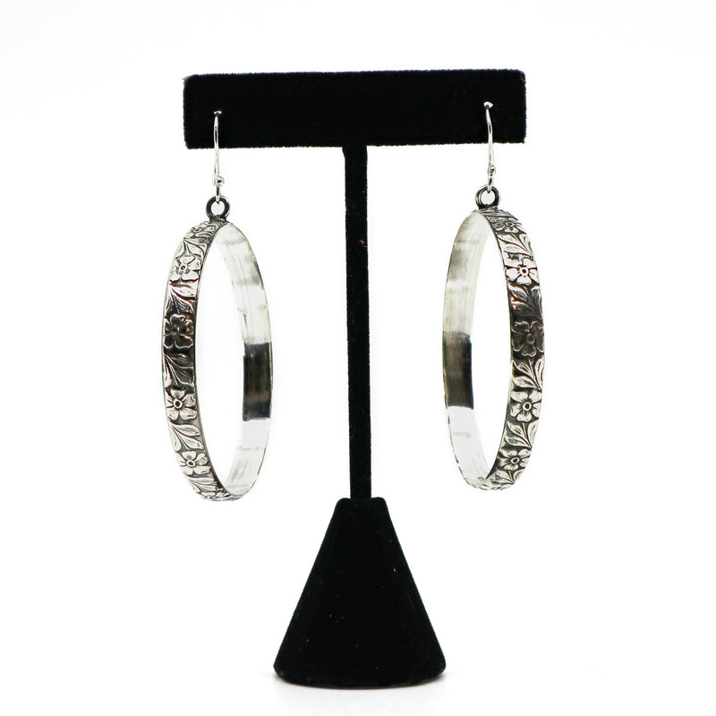 Handmade sterling silver floral hoop earrings on black stand
