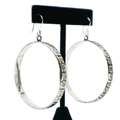Handmade sterling silver floral engraved hoop earrings on black stand