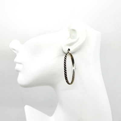Handmade sterling silver oval hoop earring on white mannequin head
