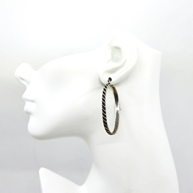 Handmade sterling silver oval hoop earring on white mannequin head
