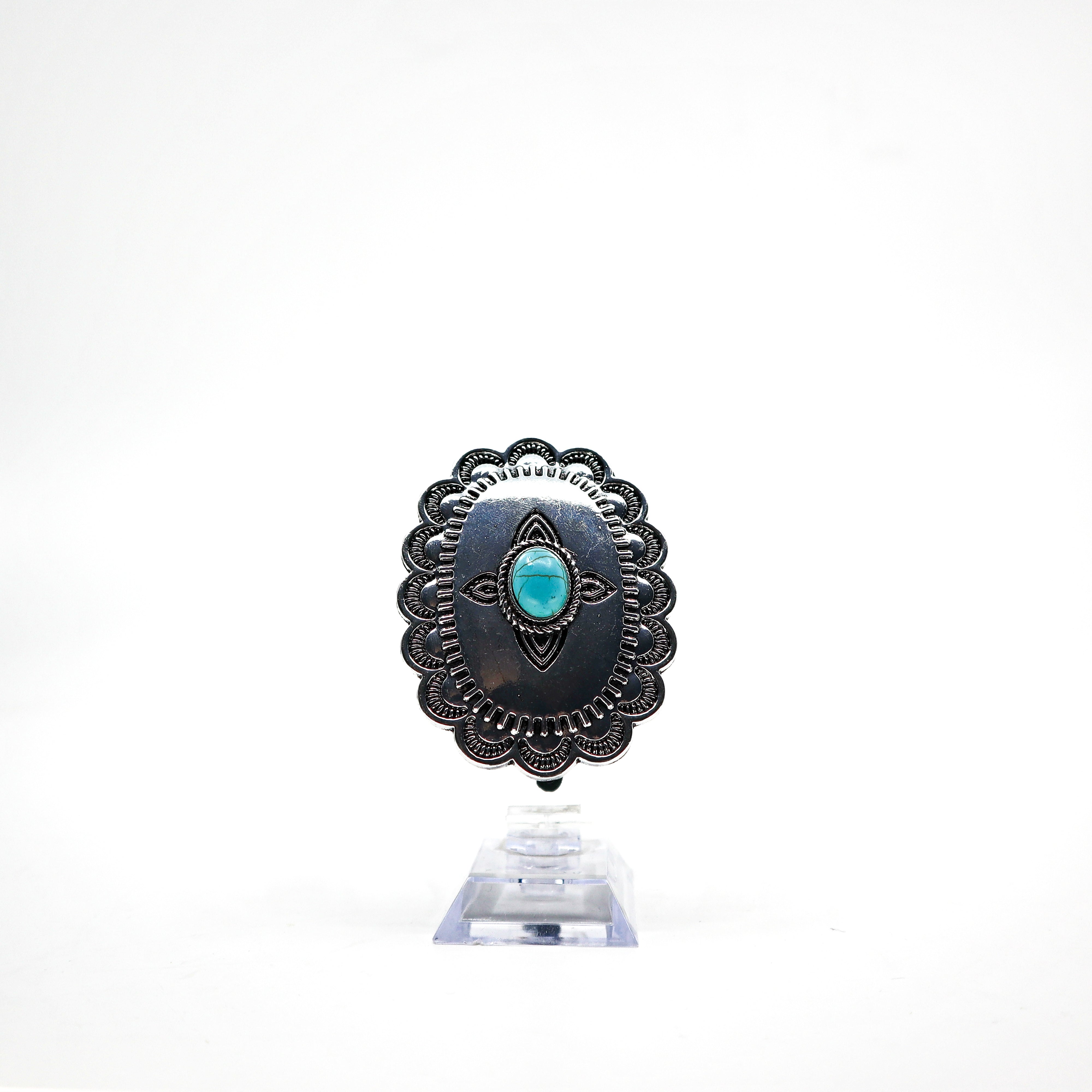Turquoise Concho ponytail holder with intricate silver detailing PSTPHC07 displayed on clear stand