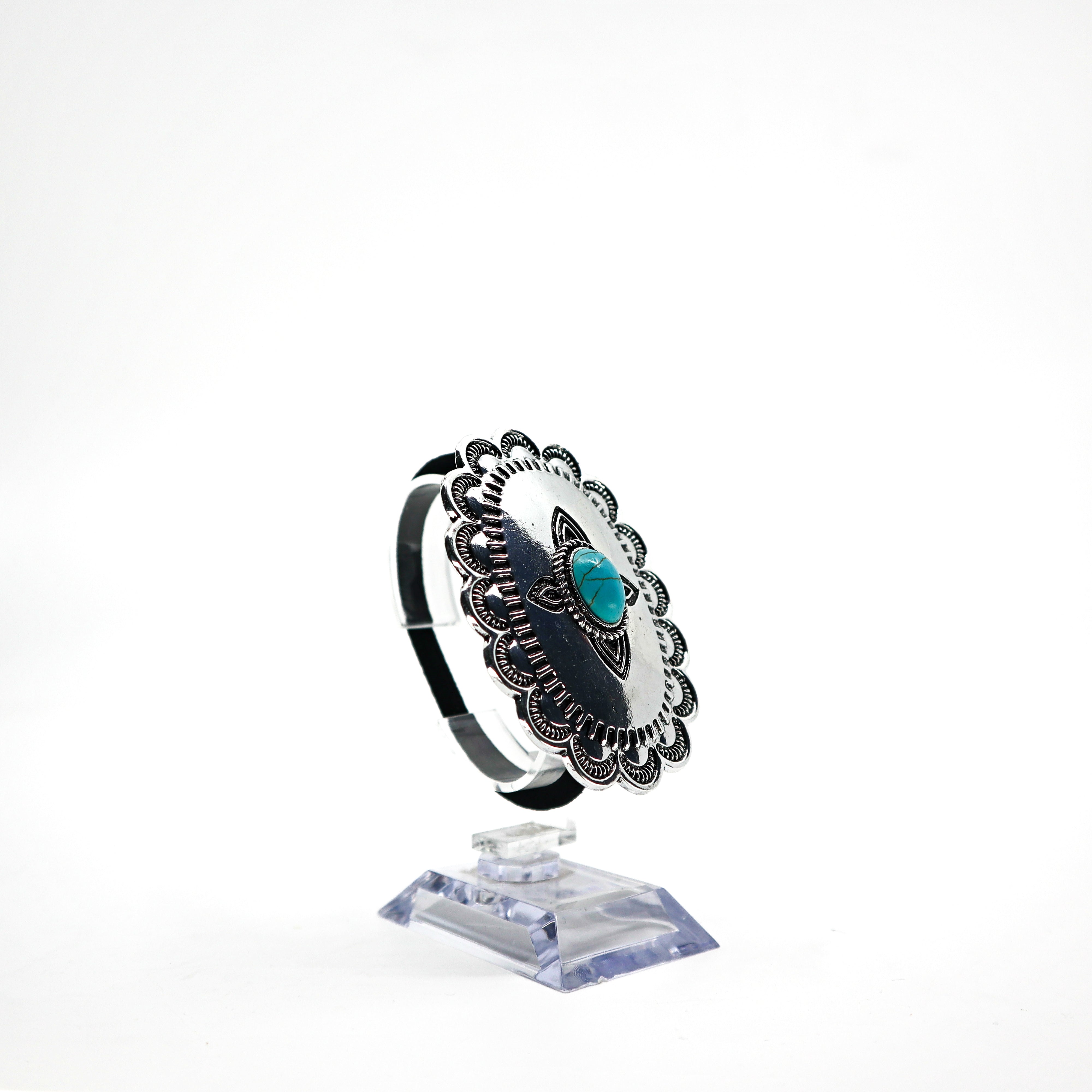 Turquoise Concho ponytail holder with intricate silver detailing PSTPHC07 displayed on clear stand
