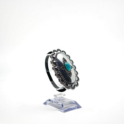 Turquoise Concho ponytail holder with intricate silver detailing PSTPHC07 displayed on clear stand