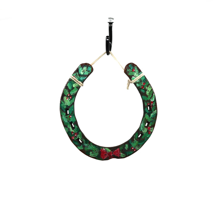 Wild Sour Hand Painted holiday horseshoe with green festive design and red bow hanging for rustic home decor