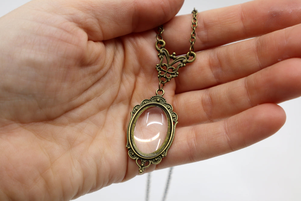 Gothic vintage magnifying glass pendant necklace with antique metal finish.