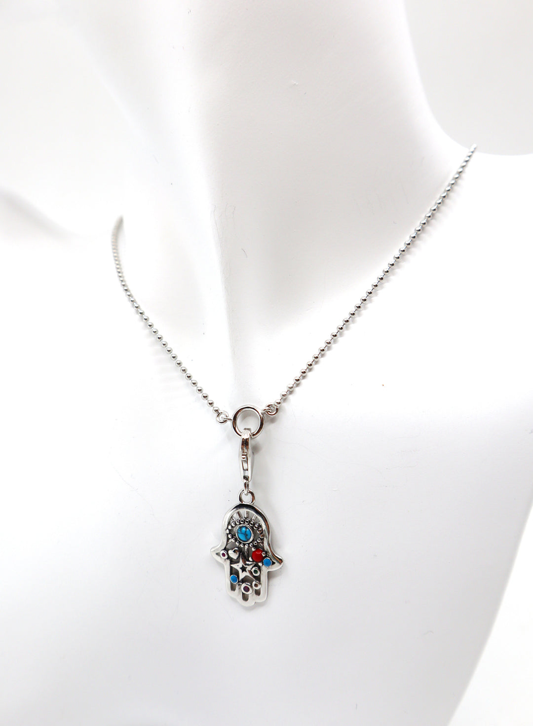 Sterling silver charm necklace with zircon gemstone on mannequin bust.