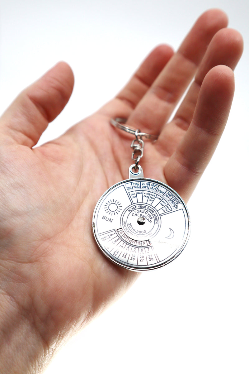 Silver 50 year perpetual calendar keychain with sleek black background and modern design