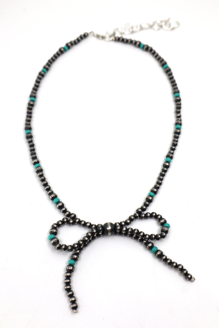 Handmade sterling silver necklace with pearl, turquoise beads, and bow design