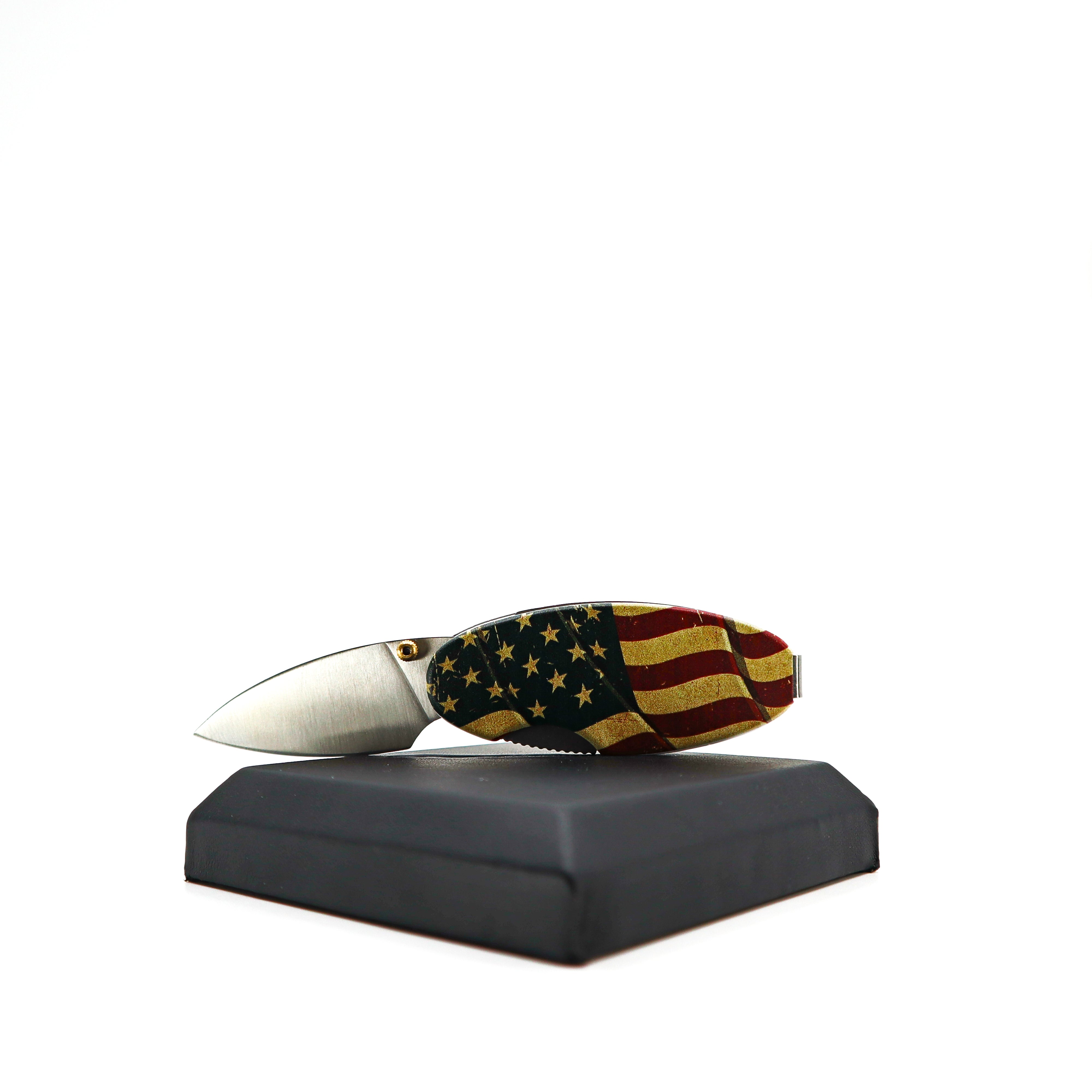 Money Clip Linerlock knife with American flag aluminum handle and satin-finish stainless steel blade displayed on black stand