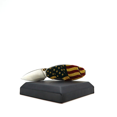 Money Clip Linerlock knife with American flag aluminum handle and satin-finish stainless steel blade displayed on black stand
