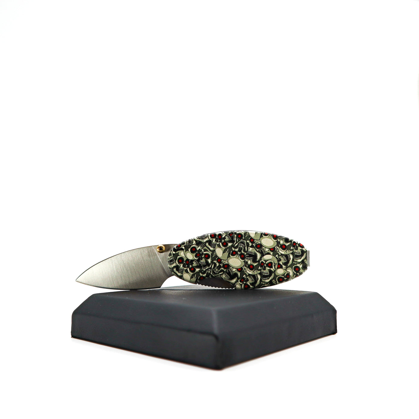 Compact Money Clip Linerlock knife with skull design handle and satin stainless steel blade on display stand