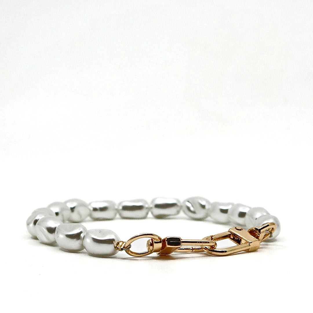 Close-up of glitter pearl phone lanyard with gold clasp and keychain attachment on white background