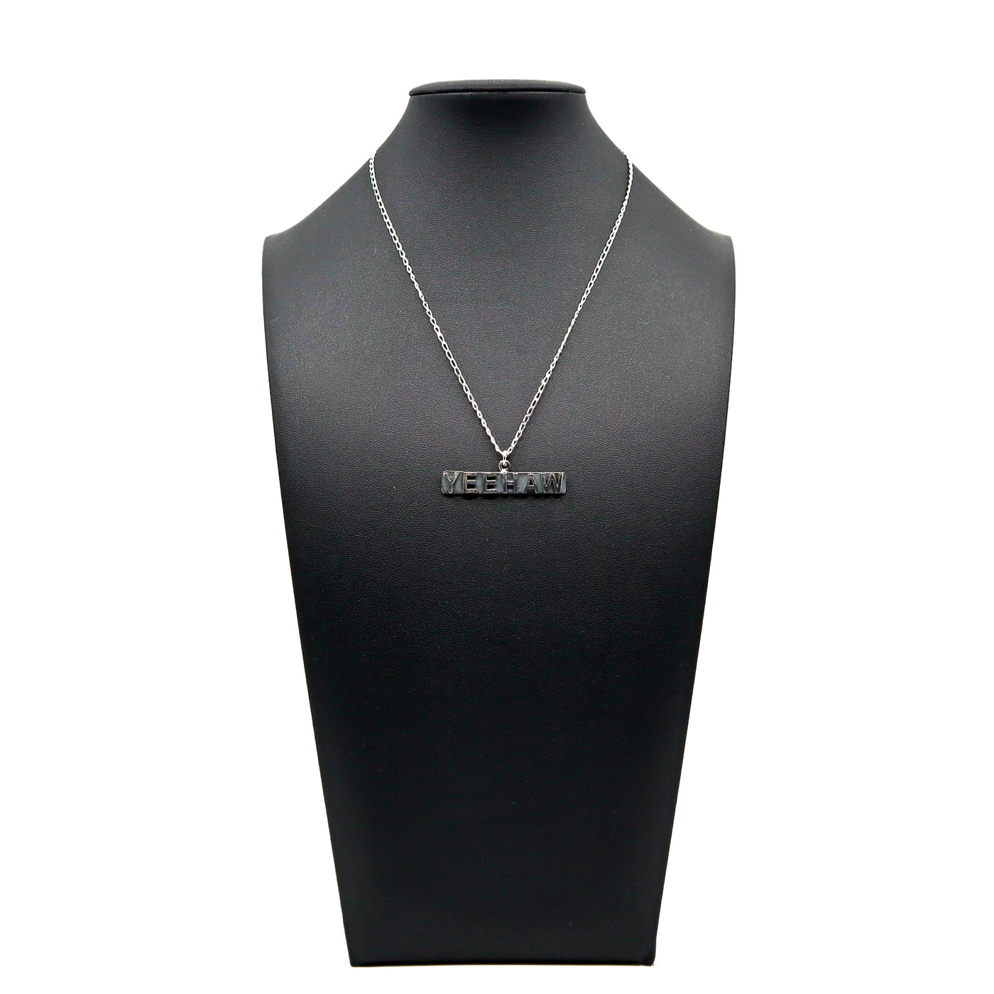 Handmade sterling silver Yeehaw necklace displayed on black stand