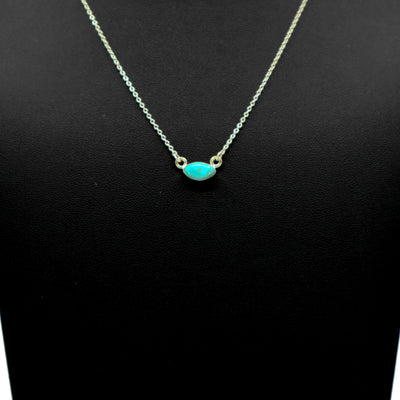 Handmade sterling silver necklace with oval turquoise pendant on black background