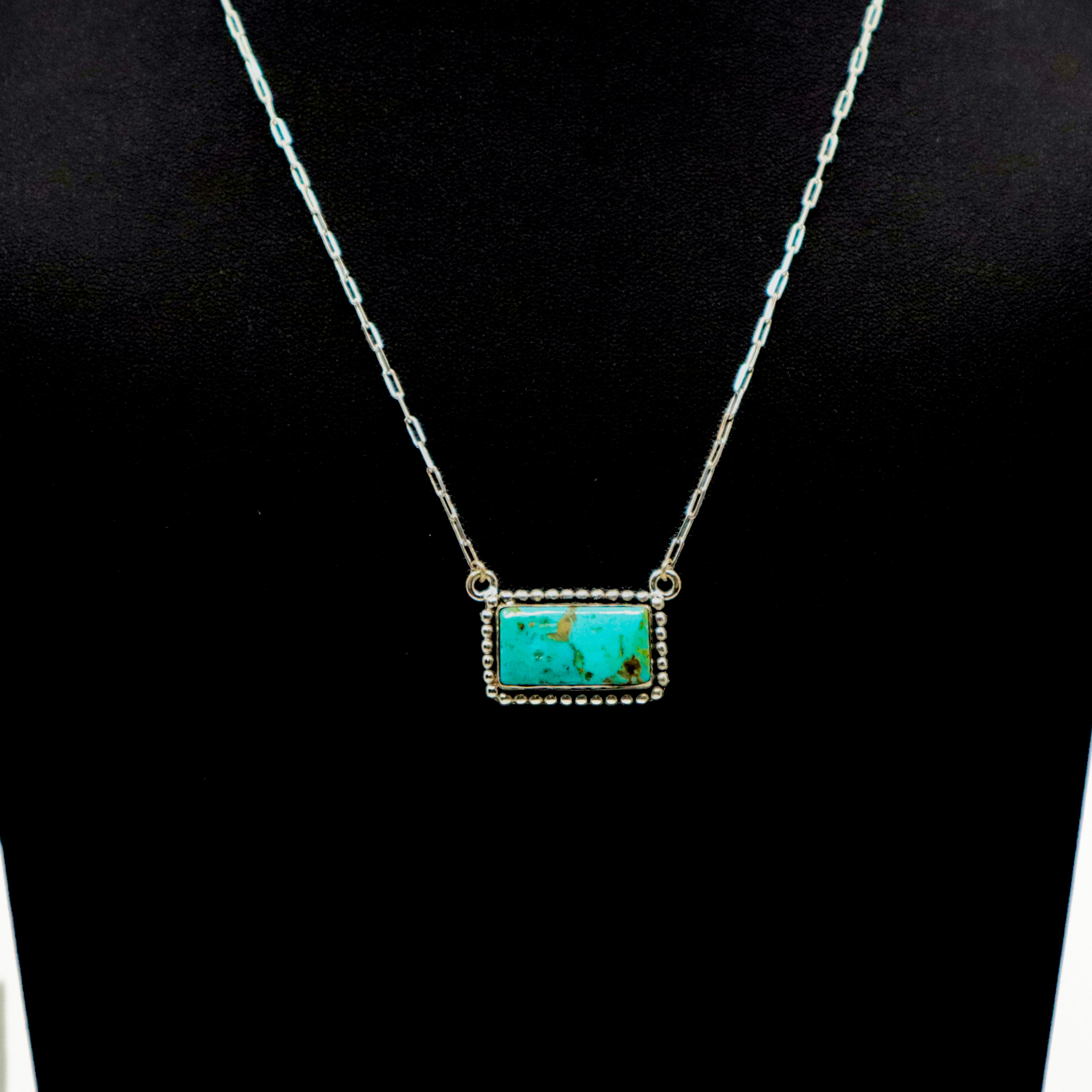 Handmade sterling silver necklace with large turquoise bar pendant and intricate border design