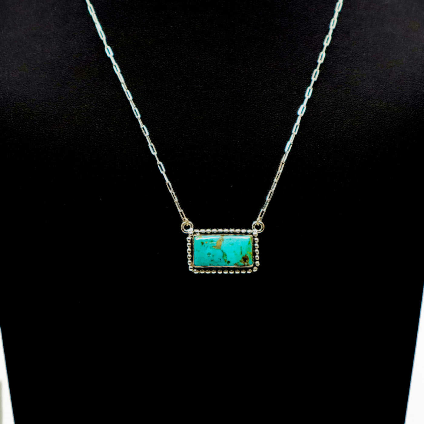 Handmade sterling silver necklace with large turquoise bar pendant and intricate border design