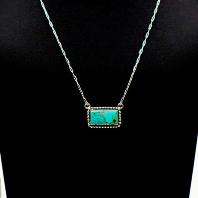 Handmade sterling silver necklace with large turquoise bar pendant and intricate border design