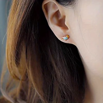 18k gold plated bird enamel stud earring on ear, showcasing playful and chic design.