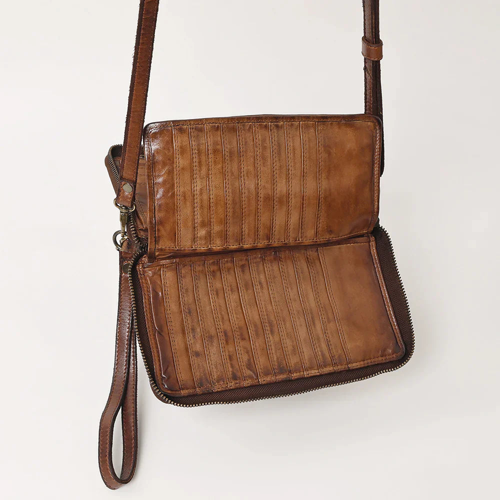 Spaghetti Western crossbody wallet in brown full grain leather with adjustable strap, antique metal fittings, YKK zipper, and decorative rivets.