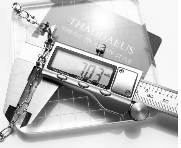 Silver link chain blackened charm bracelet with digital caliper measurement.