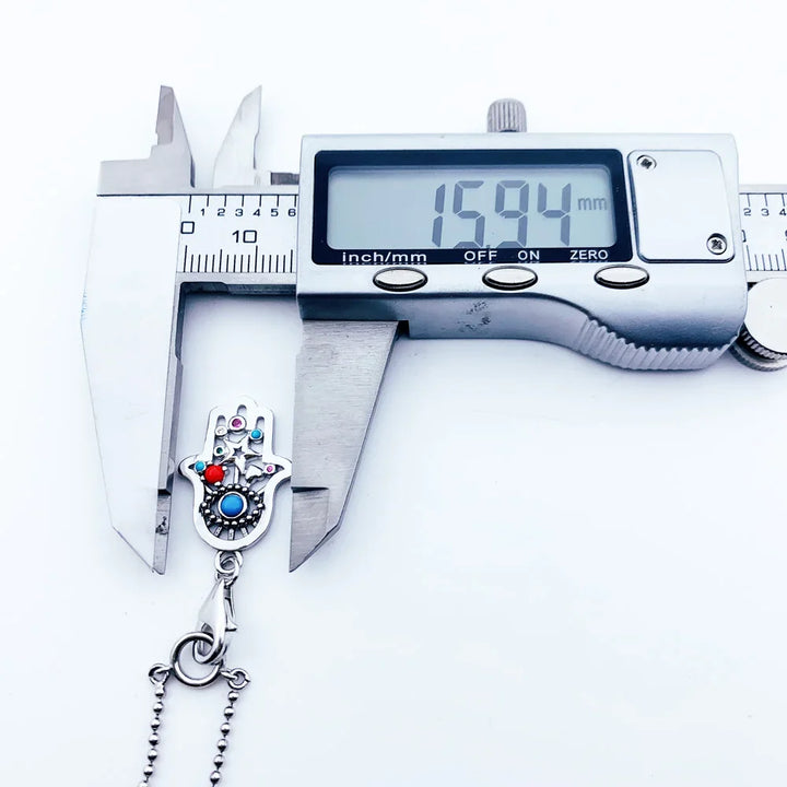 Sterling silver charm necklace with zircon gemstone, symbolic design, and digital caliper measurement.