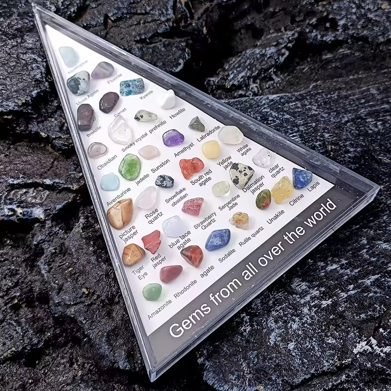 36-piece healing crystal gemstone chakra set in a triangular display case.