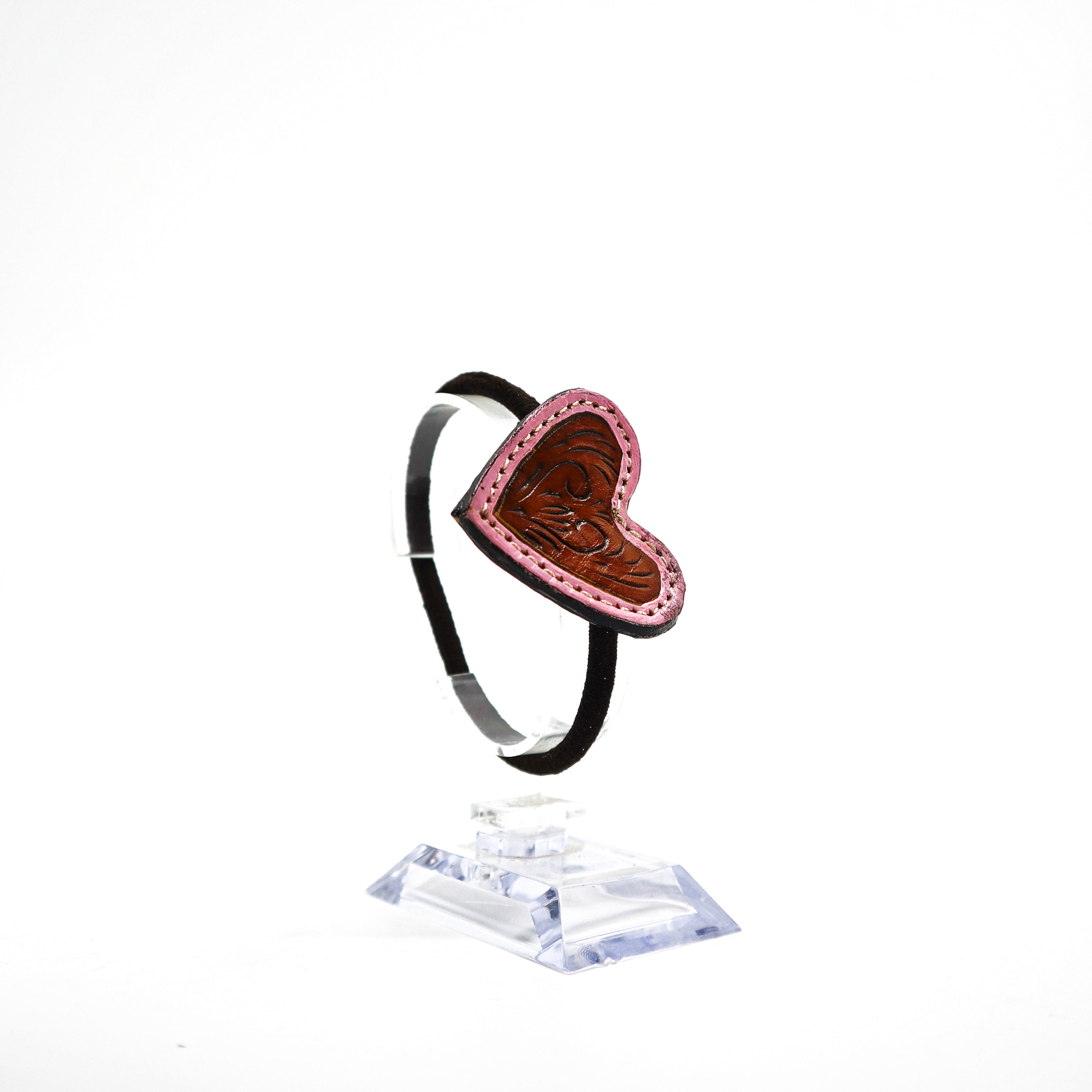 Handmade leather heart ponytail holder with hand-carved design and pink stitching