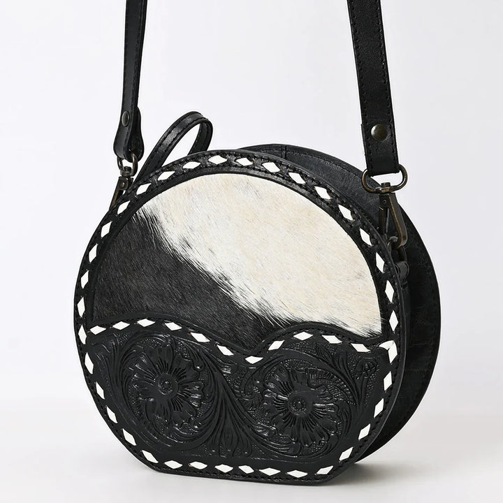American Darling Canteen Bag handcrafted from premium full grain vegetable tanned cowhide leather with hand-tooled floral designs and hair-on cowhide accents, featuring an adjustable leather shoulder strap and antique finish metal fittings.