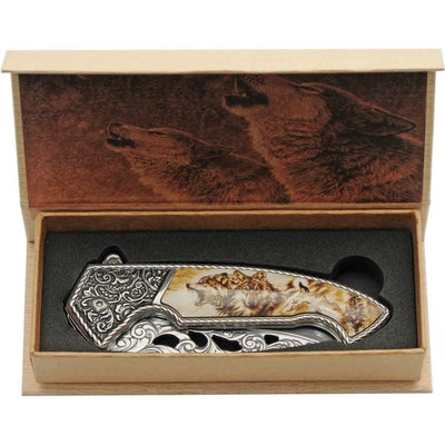 Framelock knife with detailed wolf design handle in a decorative wooden box