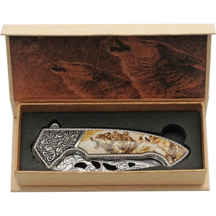 Framelock knife with detailed wolf design handle in a decorative wooden box